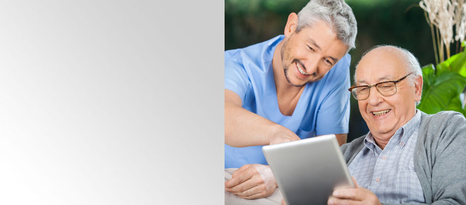 Senior Resident in Care Facility Enjoying Tablet Computer Game With Nurse